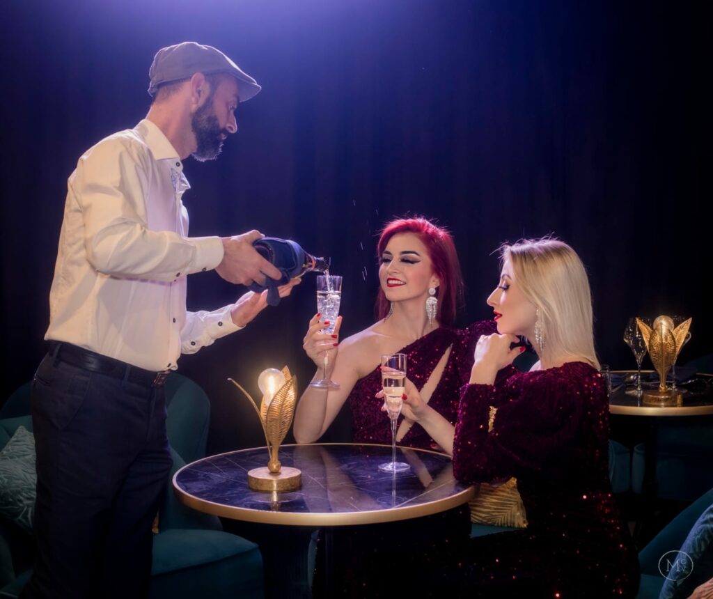 homme servant du champagne à deux femmes dans un cabaret